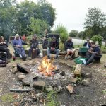 Image of men sat around a campfire