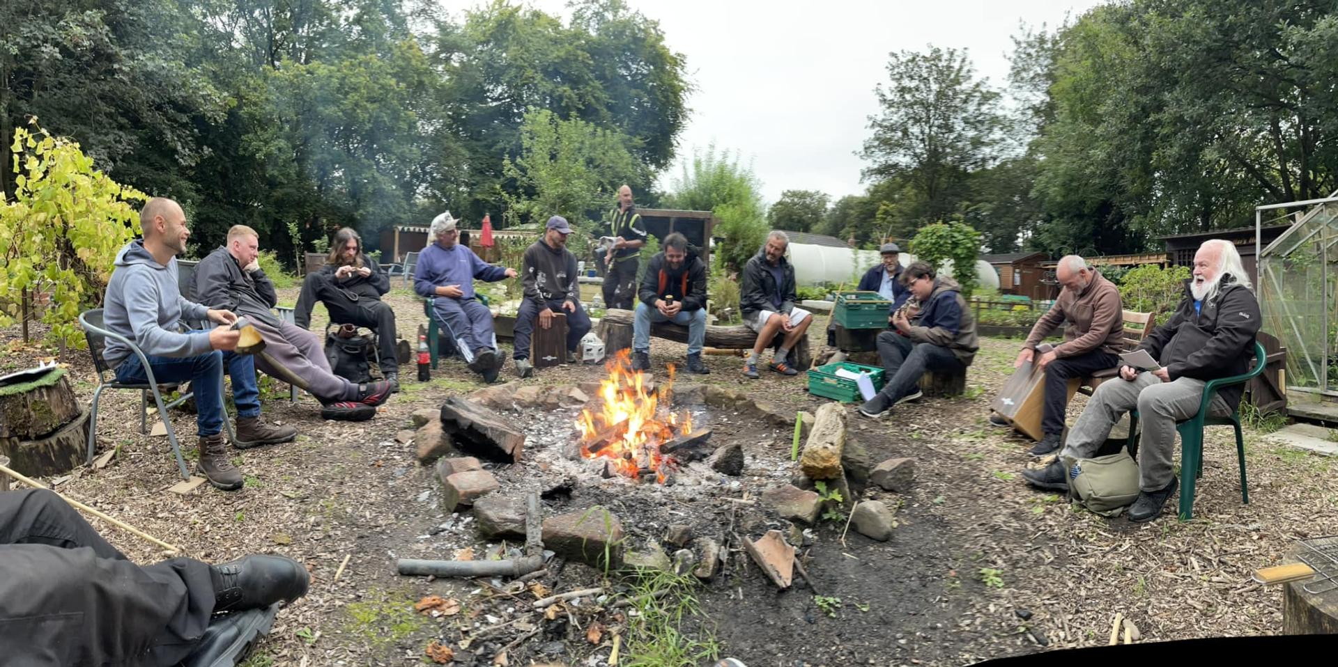 Image of men sat around a campfire