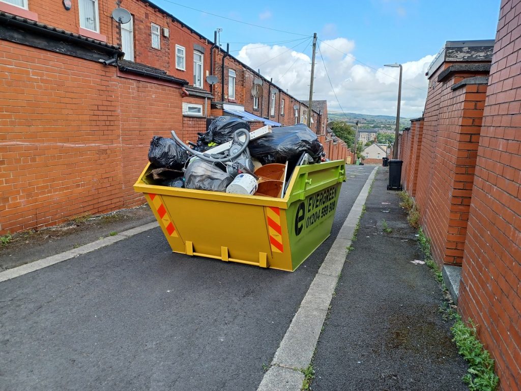 A skip filled with rubbish in a back street