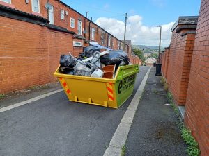 A skip filled with rubbish in a back street