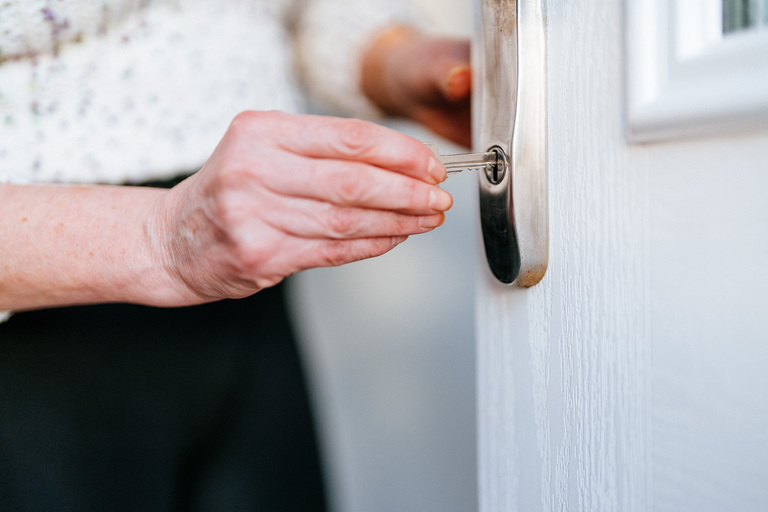 A key being inserted into a keyhole on a front door.