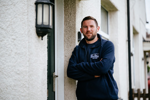 Male repairs operative stood outside the front door of a Be One Homes property.