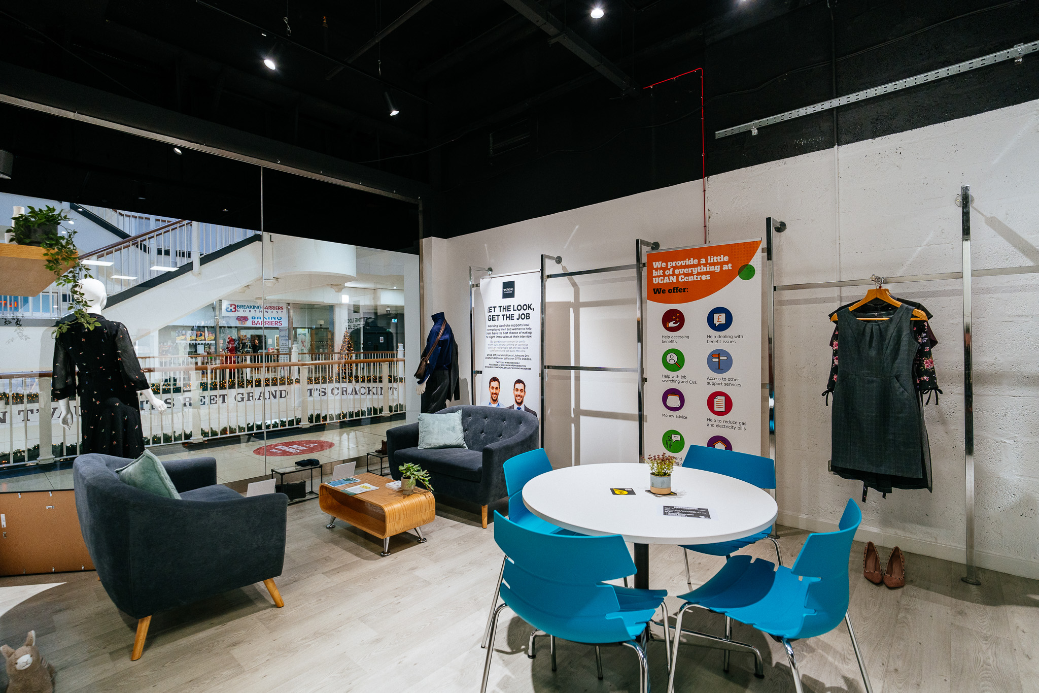 An interior shot of our Bolton UCAN Centre. It shows a pull-up banner that lists the services available at the centre, along with seating areas for visitors.