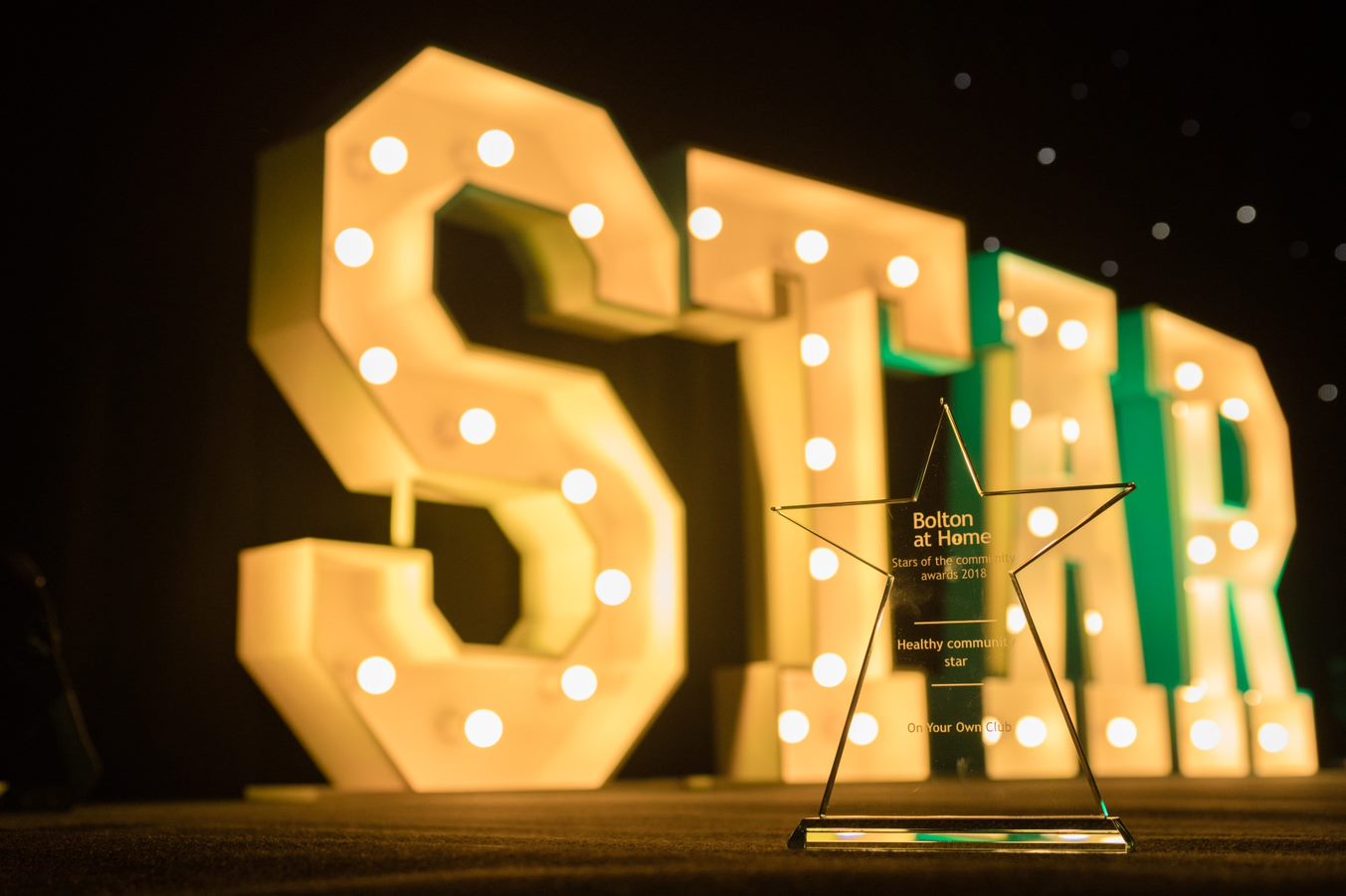 Large illuminated text at our Stars of the Community Awards event reading 'STAR'.
