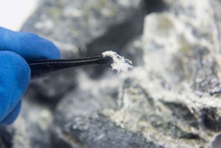 Asbestos fibres held with tweezers.