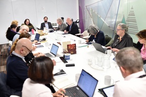 A meeting between colleagues at our Valley House office. There are many colleagues sat around a large table.