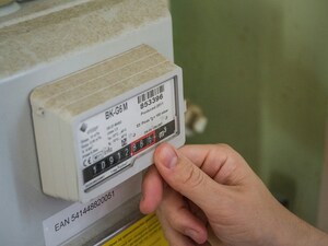 A gas meter. A person's hand is visible in the shot as they take the meter reading.